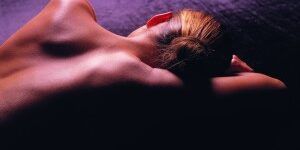 CIRUGIA-INTIMA-300×212 Silueta de una mujer recostada con iluminación violeta, imagen ilustrativa de cirugía íntima